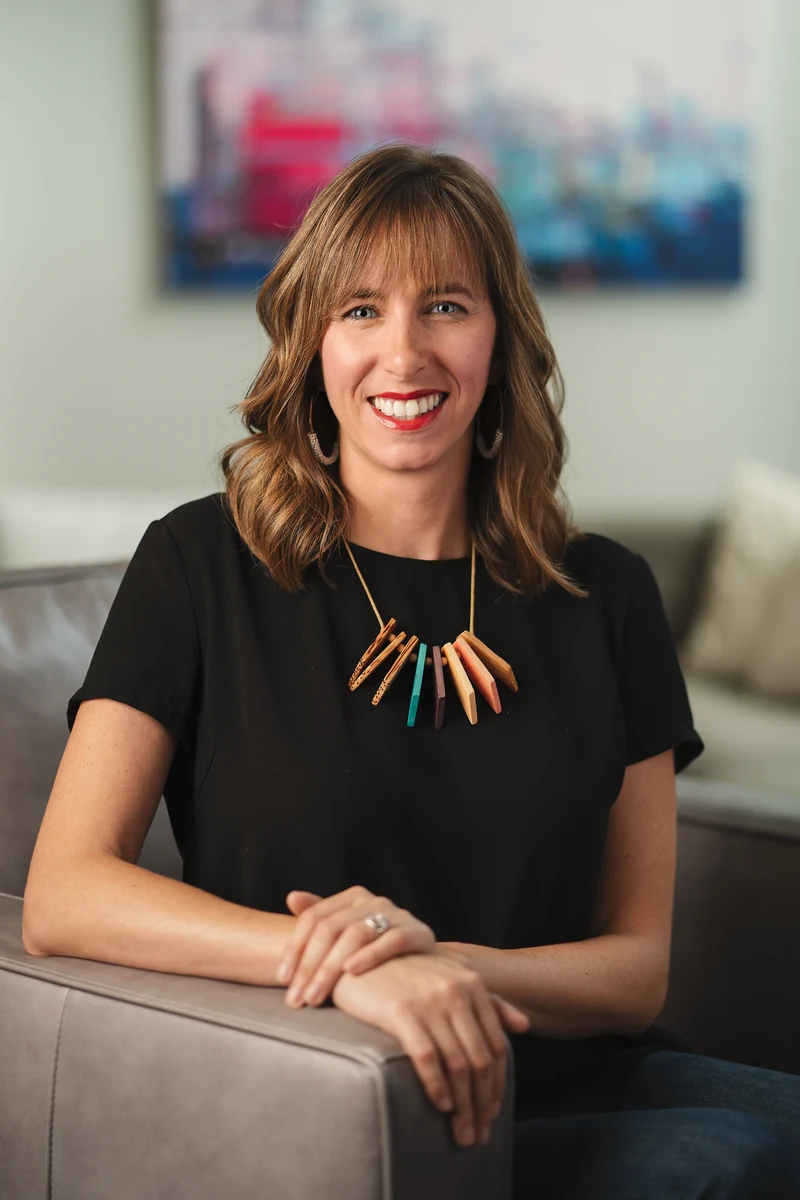 Woman in a black top seated in a bright office interior