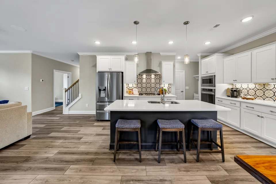 White kitchen with a large island and pendant lights