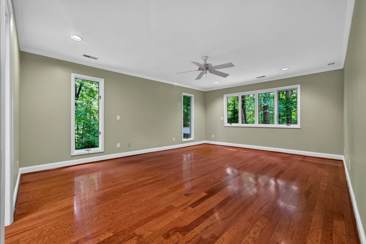 Garner bedroom with windows overlooking the wooded property