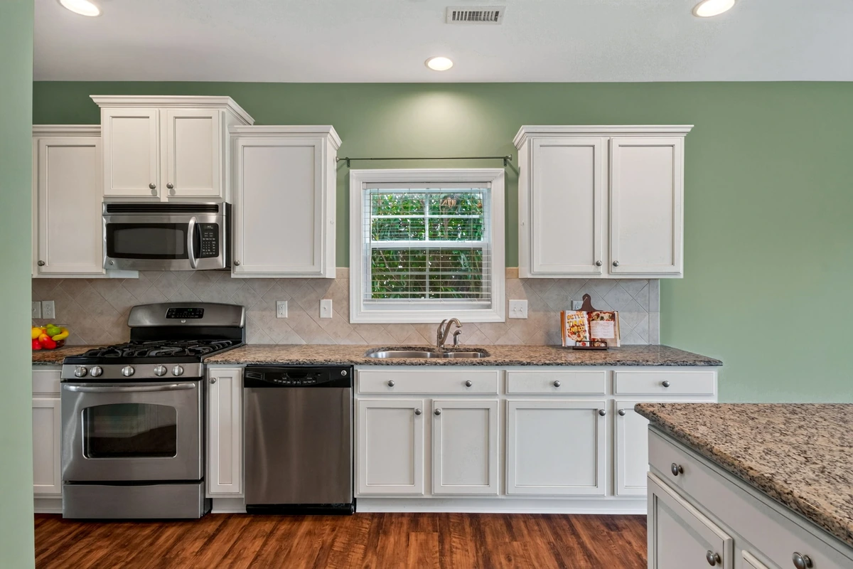 Raleigh kitchen with white cabinets, counters, and stainless appliances
