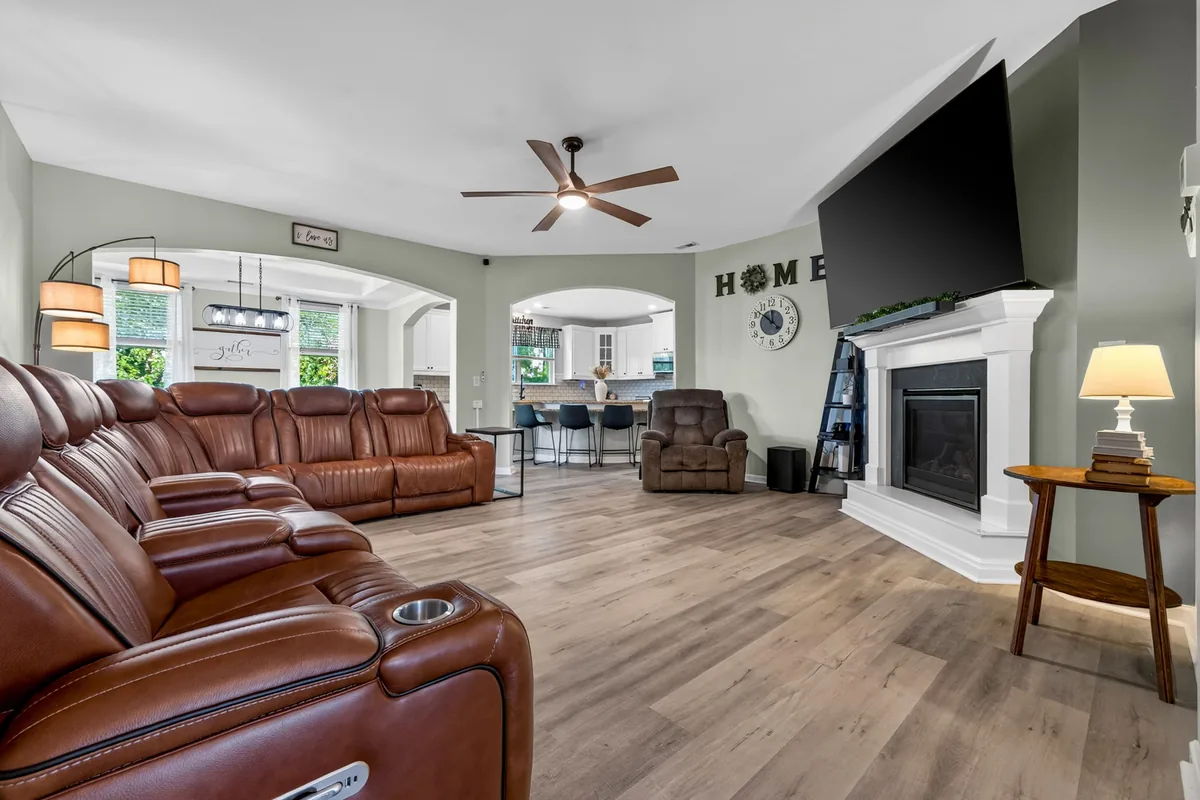 Rolesville living room with tall windows and a view into the open plan