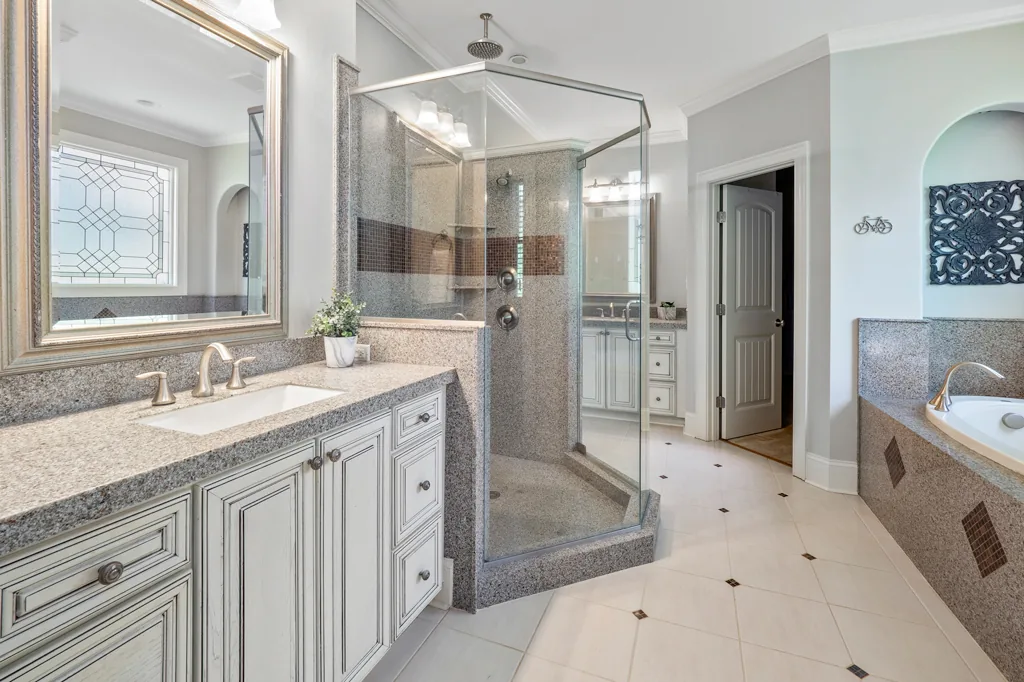 Clean, polished bathroom with clear countertops and neatly arranged towels