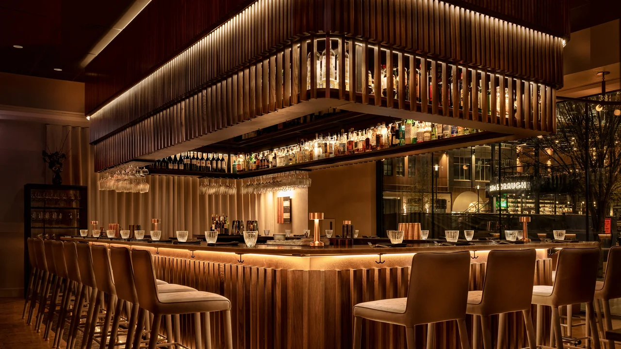 Warm architectural bar interior with an illuminated wood feature