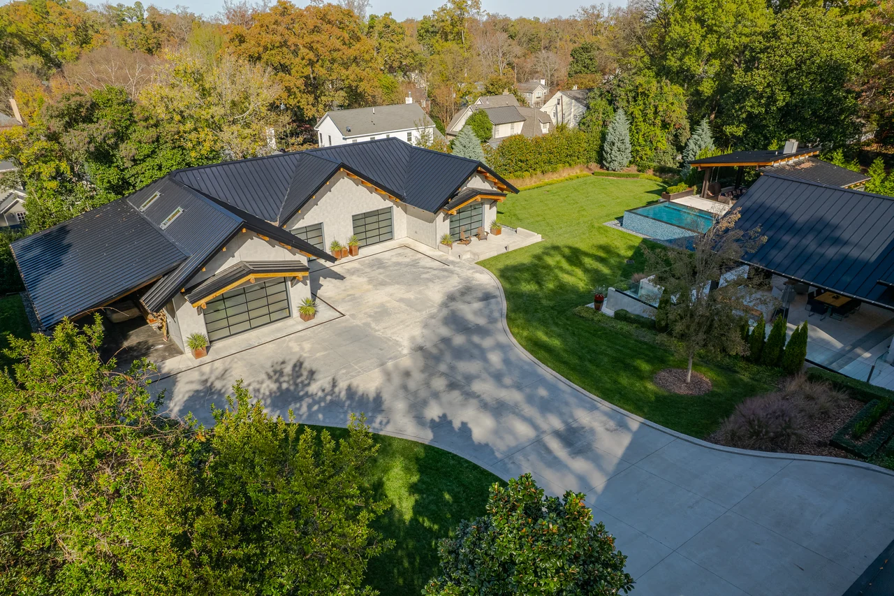 Aerial view of a luxury home, swimming pool, and landscaped grounds