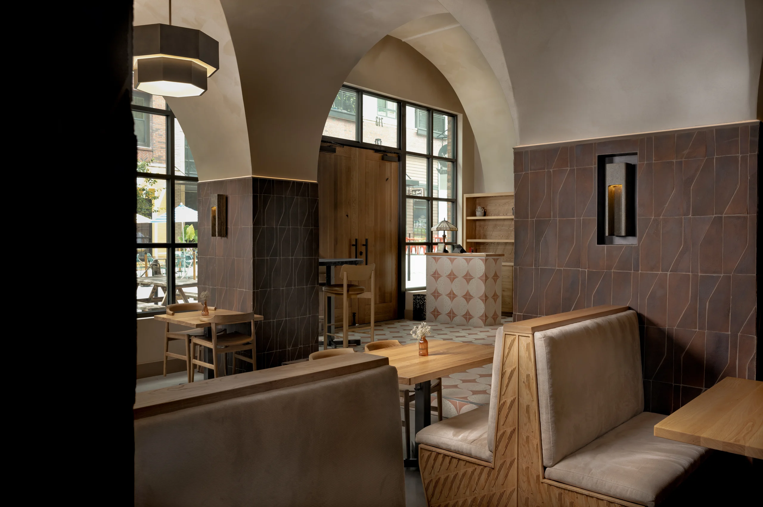 Architectural interior detail showing arched ceilings, tile, wood, and built-in seating