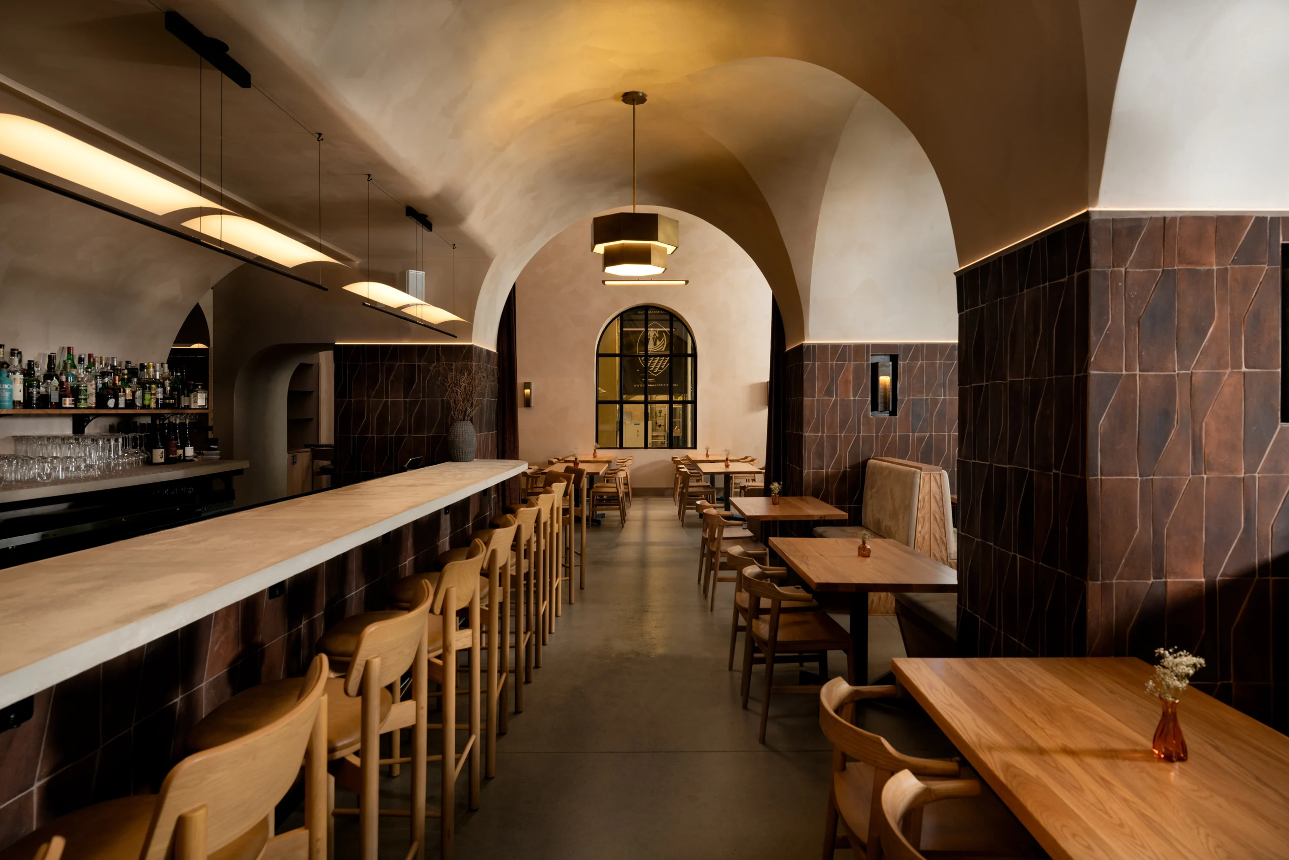 Hospitality bar interior showing its vaulted spatial sequence and material palette