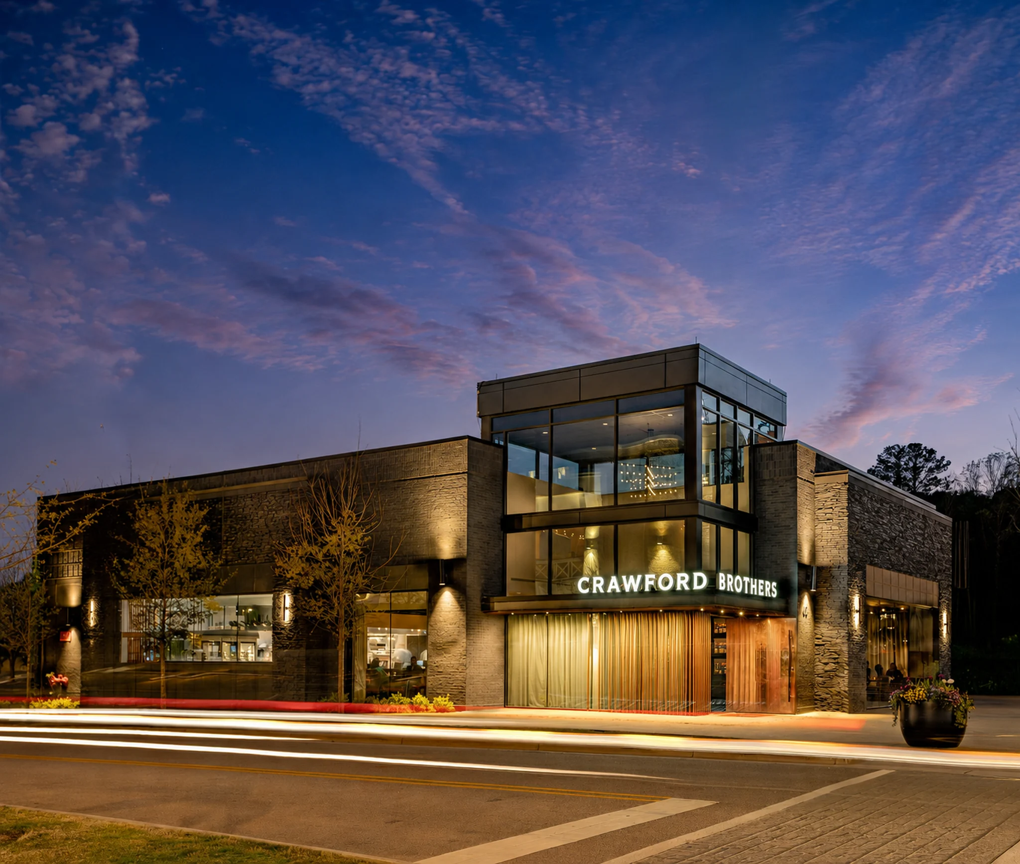 Contemporary Crawford Brothers building photographed at blue hour with its glass tower and illuminated entrance